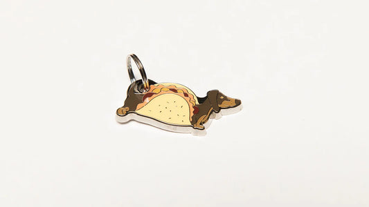 Apportez la saveur du Mexique à votre chien avec la Médaille pour Chien Hot Dog Tacos de la marque Mexie. Cette médaille ludique arbore un motif unique de teckel en forme de saucisse garnissant un délicieux tacos, célébrant l'essence de la cuisine mexicaine