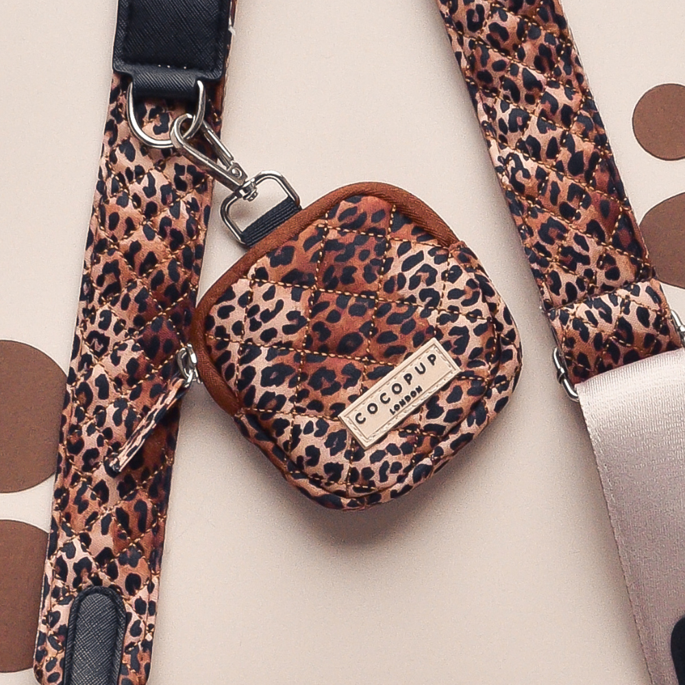 Pochette à friandises matelassée avec imprimé léopard, fermeture éclair, et clip pour fixation à un sac ou vêtement.