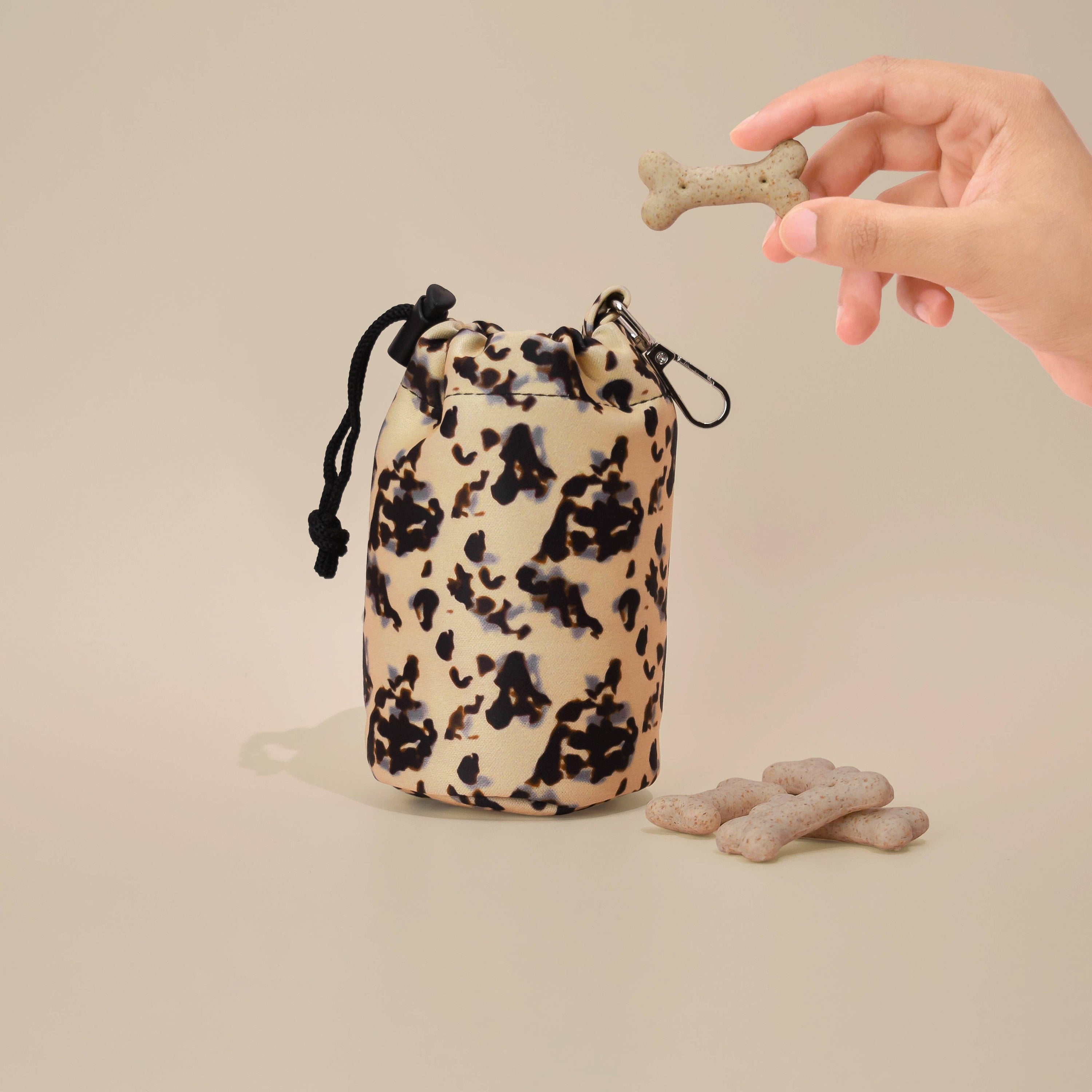Pochette à friandises ivoire avec cordon de serrage, imperméable et pratique, posée sur un fond neutre et élégant.