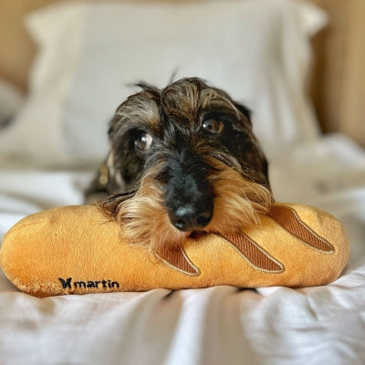 Jouet peluche en forme de baguette pour chien Martin Sellier, fabriqué en tissu recyclé, avec couineur et papier bruissant.